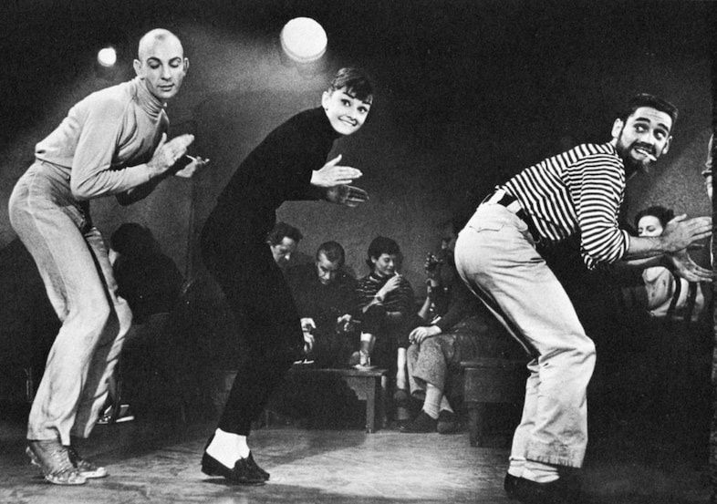 Black-and-white group dancing in expressive mid-century casual clothing