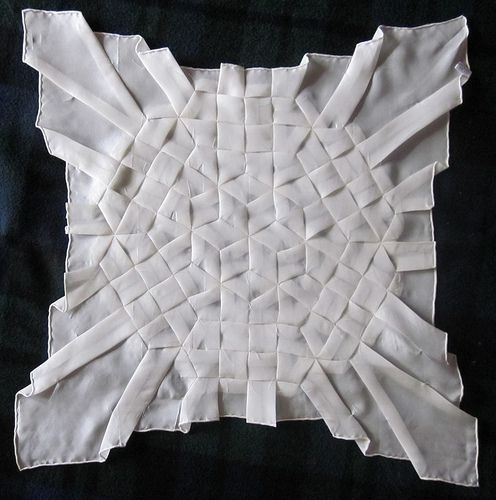 White fabric square covered in intricate hand-folded pleats