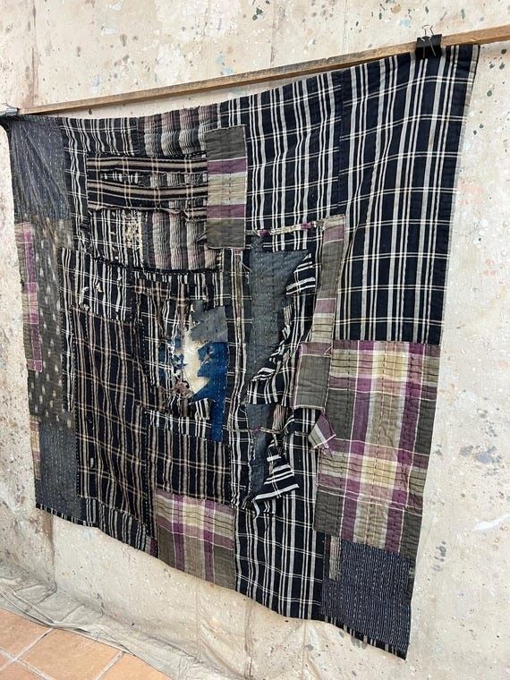 Large black-and-white plaid textile covered in colorful visible patches